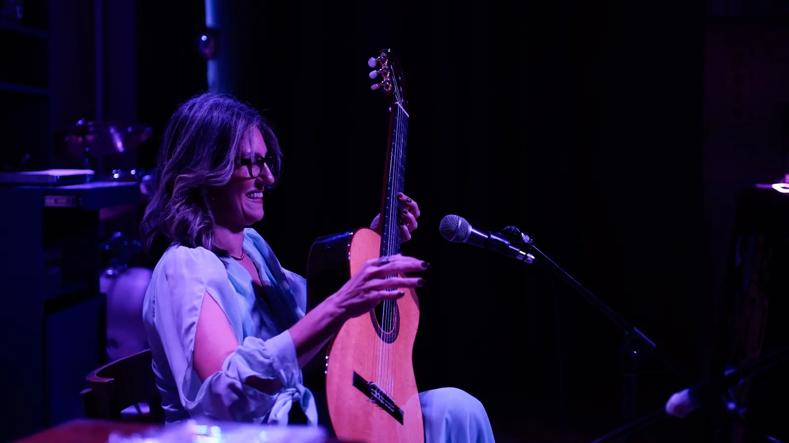 Carmem Di Novic sorrindo com violão